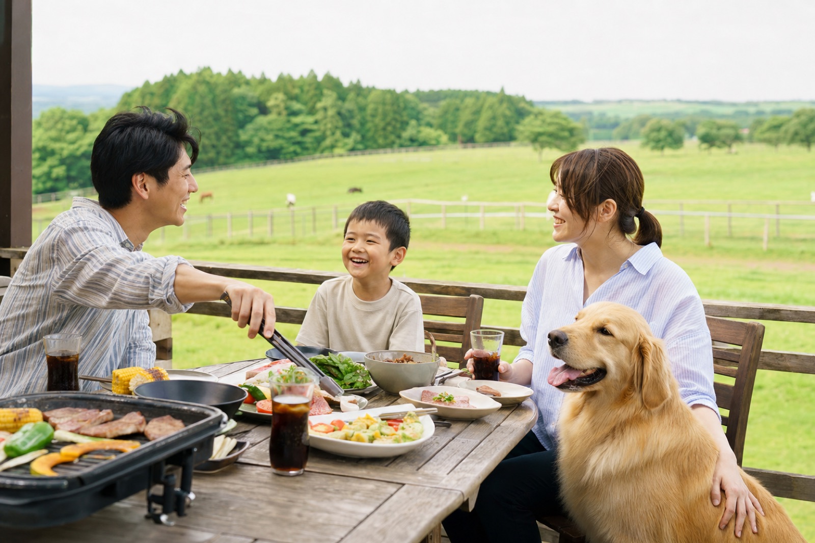テラス席で愛犬のゴールデンレトリバーと一緒に食事をする家族
