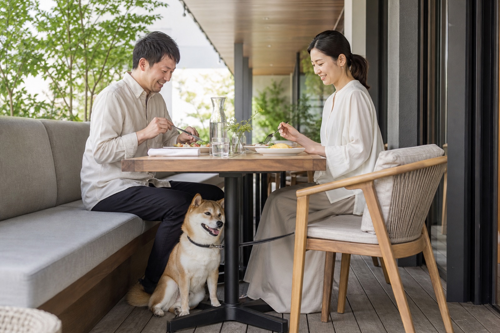 テラス席で柴犬と一緒にランチを楽しむ日本の夫婦